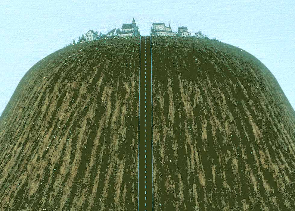 View from the driver's seat of a car, showing a bodacious hill ahead-- here focusing on the small town at the top of the hill