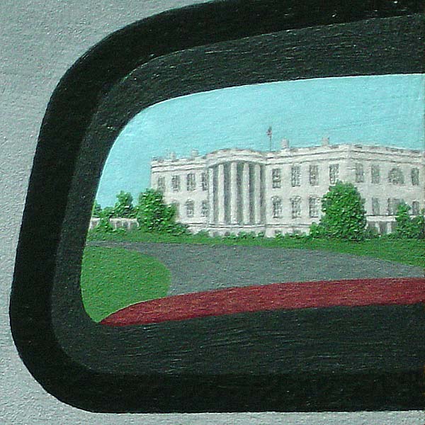 View from the driver's seat of a car, showing highway running through desert-- detail of rearview mirror