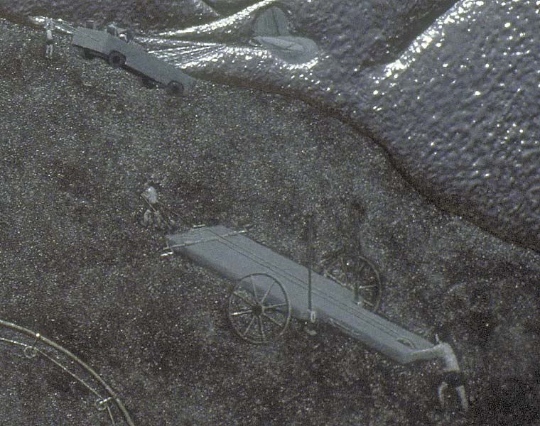 Detail of painting of two-man teams competing to pull crashed airplanes out of the ground, focusing on winch wagon